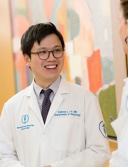 Three MSK Colleagues in lab coats smiling and chatting