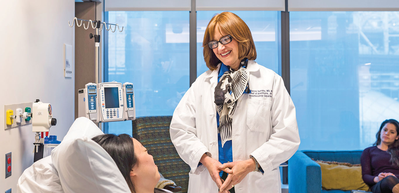 Medical colleague smiling at patient in a bed